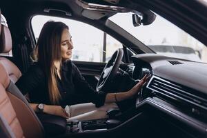 Customer testing navigation system in new car at dealership showroom photo