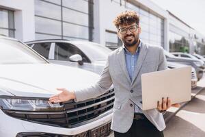 Car salesman showing a new car to the customer in car dealership photo