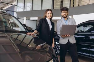 Salesman showing new car to customer in dealership photo