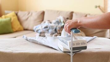 A person using an iron to iron a couch video