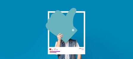 A person is interacting with a popular social media application by showing a thumbs-up gesture. The background features a vibrant blue color, perfect for creating engaging content. photo