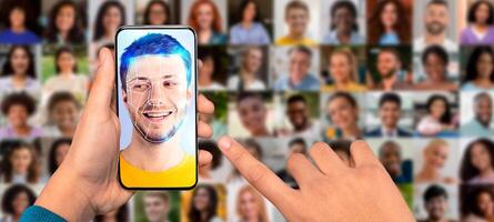A hand holds a smartphone displaying a facial recognition scan of a young man. Behind are multiple portraits of diverse people, highlighting modern identification technology in use. photo