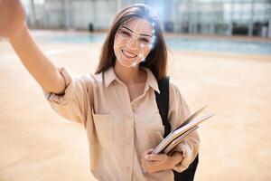 A person smiles while holding a notebook, engaged in a facial recognition check during a technology demonstration outside. This showcases the advancement of identification methods in today's society. photo