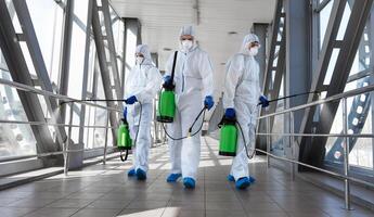 Biological hazard. Epidemic of the coronavirus. Men in a protective suit and mask disinfecting tunnel with gas. photo