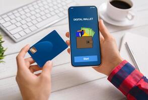 Man using smartphone with digital wallet application making payment from credit card at workplace in office, closeup photo