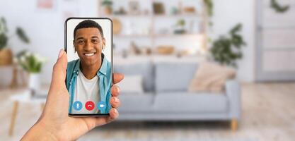 A person is holding a smartphone displaying a cheerful individual during a communication session. photo