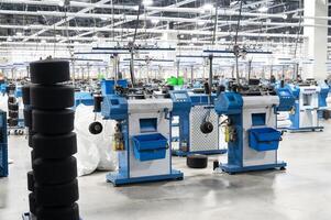View of automated textile manufacturing machines in a factory, with spools of white thread ready for processing. photo