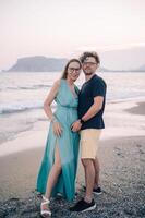 A smiling couple shares a joyful moment on the beach at sunset, the man and the woman near the sea waves, Alanya, Turkey photo