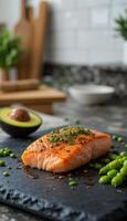 vertical cooked Fresh Salmon Slice on Black Lava Stone Tray with Avocado Sides photo