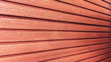 Close-Up of Red Wooden Wall with Horizontal Planks Creating a Textured and Rustic Architectural Background photo