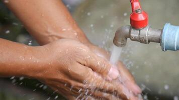 Hands Washing Under Running Water from Outdoor Faucet for Hygiene and Cleanliness Concept photo