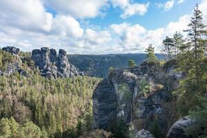 Rocky formation mountains foreground and background in the green forest cloudy day photo