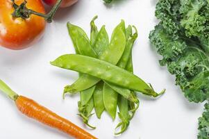 a white table with a bunch of vegetables and a carrot photo