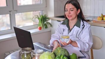 A nutritionist doctor conducts an online consultation with patients at a table. The benefits of drinking water with lemon. Water balance. The concept of nutrition, detox, fitness. video