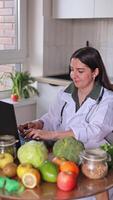 A nutritionist works at a table and communicates with patients via a computer, makes a meal plan and diet. Health and diet concept, clinic, wellness. video