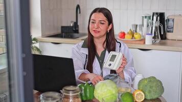 A doctor works with patients online at a table, showing a tonometer and capsules of pills. Consultation for people with high blood pressure and pulse. Health and diet concept, clinic, wellness. video
