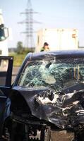 A crumpled hood, a broken windshield and deployed airbags in a car after an accident photo