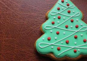 Christmas And New Year Holidays Background With Gingerbread Cookie In Shape Of Pine Tree With Decorative Icing photo