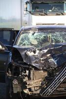 Broken engine compartment and mangled car engine after a head-on collision at high speed photo