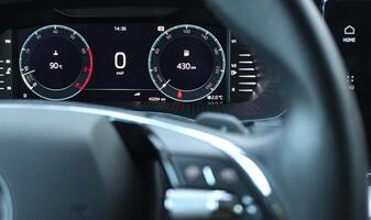 Engine operating temperature and remaining mileage before refueling at the instrument cluster on LED car dashboard photo