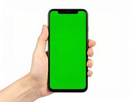 Hand displaying a smartphone with a chroma key green screen on a plain white background photo