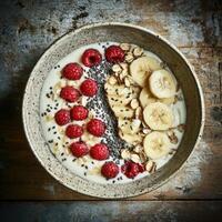 Creamy yogurt bowl beautifully arranged with ripe raspberries, sliced banana, rolled oats, and nutritious chia seeds photo
