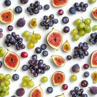 Flat lay of various fresh fruits including figs, green and purple grapes, and blueberries scattered on a clean white surface, creating a colorful and healthy food pattern photo
