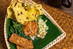 Authentic Javanese Pecel in Triangular Bamboo Plate Isolated Background photo
