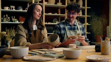 Caucasian woman man couple date handmade master class in pottery workshop potter sculptor artist modeling clay together crafts hobby enjoying handcraft in art studio happy girl guy smiling high five video