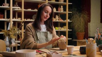 Smiling girl Caucasian woman artist sculptor craftswoman potter designer art work in studio small business owner decorator in pottery workshop clay modeling crockery creation hobby handmade craft shop video