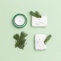 Christmas handmade gifts box or presents decorated with natural fir branches and cones, aroma candle. New Year flat lay photo