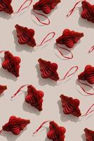 Red Christmas ornaments, winter holiday minimal photo pattern with sunlight shadows. New year red golden shiny flashlights on beige, Christmas paper baubles, hand cut xmas decor, top view