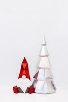 Cute Christmas gnome and holographic paper Christmas tree, paper polygonal figures dwarf and fir tree photo