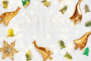 New Year frame, shiny Christmas ornaments gold mushrooms, green tree and glowing star on white fur background. Glittering holiday aesthetic flat lay. Festive celebration mood, top view, copy space photo
