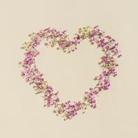 Small pink flowes on beige color. Narural frame in shape of heart. Minimal style aesthetic card for wedding invitation photo