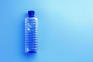 Clear plastic water bottle with blue cap on light blue background with soft shadow, copyspace. Minimal top view photo, themes of ecology, recycling, sustainable living, reduce disposable plastics photo