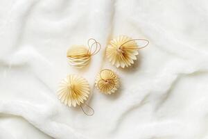 Minimal style winter holidays top view composition with New Year paper festive ornaments cream beige Christmas balls on White Faux Fur Texture background, copyspace. Neutral tones, soft shadows photo