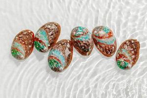 Colored shells floating on waves transparent sea water with sun flare. Natural textured Seashells of natural bright and shimmering at sunlight, Minimal aesthetic still life photo, summer vibes photo