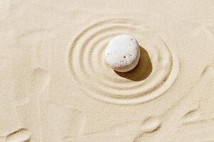 Aesthetic minimal background with zen stone on sand. Japanese Zen Garden with concentric circles around stone cairn. photo
