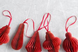 Red Christmas Paper flashlights different shapes, Christmas tree stylish ornaments for winter holidays, minimal style New Year flat lay pattern with copy space, greetings card or holiday background photo