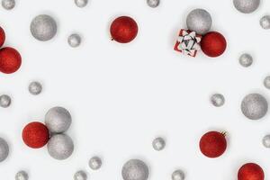 Christmas frame with sparkly red and silver Christmas balls and small gift box or present on white background. photo