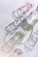 Water Glasses and water jug with Shadows and sunlight Reflection on white background, colored photo minimal style, aesthetic summer still life, refraction crystal shine cups, caustics