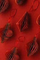 Red Christmas paper baubles shapes of flashlights on red paper background, as minimal trend graphic pattern, Scandinavian Christmas honeycomb ornaments. New year paper decor, modern xmas decorations photo