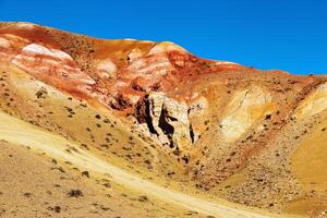 Fantastic red mountains with bright color transitions and blue clear sky in place named Mars 1, Altai Republic photo