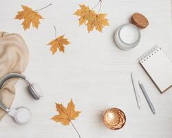 Autumn flat lay home relaxation with notebook for sketches and headphones, glass of water, aromatic candle photo