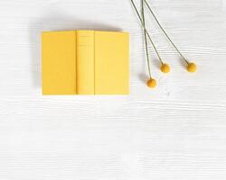 Close-up of open book in yellow cover Concept of reading books and taking break from gadgets. photo