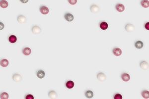 Bright holiday frame with sparkling balls on white background with copy space. Birthday or anniversary celebration concept photo