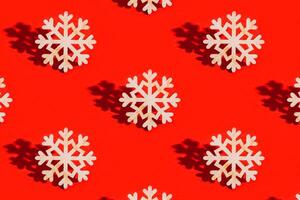 Christmas pattern with wooden snowflake on red Decoration for winter celebration New Year holiday concept photo