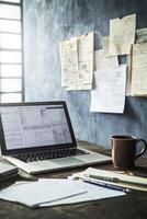 Mood boards cover the wall while a designer works at a laptop amid crumpled papers and a coffee cup photo