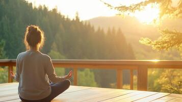 A woman enjoys yoga on a serene wooden terrace, surrounded by lush trees and bathed in gentle morning sunlight photo